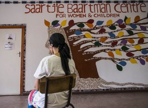 December 2 2015 - The Women’s Centre: Kamiela sits at the entrance to the Women’s Centre in front of her favourite mural. The Saartjie Baartman Centre for Women and Children, based in Klipfontein Road in Manenberg, is a one-stop centre for women & children who are survivors of abuse; Kamiela has been living at the safe haven for six months partcipating in the kitchen program as part of her ongoing care. Picture by David Harrison